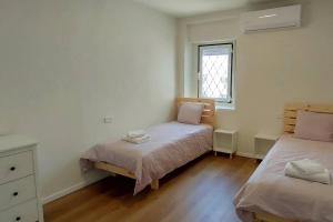 1 Schlafzimmer mit 2 Betten und einem Fenster in der Unterkunft Desert Breeze in Mitzpe Ramon