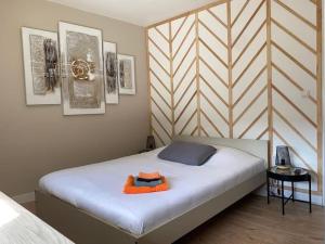 sypialnia z łóżkiem z pomarańczowym ręcznikiem w obiekcie Le Cosy 120m² - 4 chambres - 8 personnes w mieście Woippy