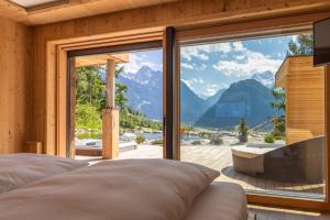 a bedroom with a large window with a view of mountains at Chalet Residenz Zillertal Mühlermoos in Ramsau im Zillertal