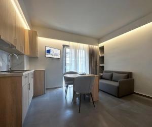 a kitchen and living room with a table and a couch at Rodosrooms in Rhodes Town