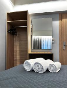 a pile of towels on a bed in a bedroom at Rodosrooms in Rhodes Town
