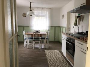 eine Küche mit einem Tisch und Stühlen sowie ein Esszimmer in der Unterkunft Villa Rosa in Bad Rodach