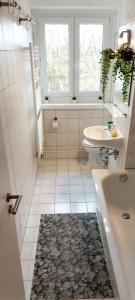 ein Badezimmer mit Badewanne, Toilette und Waschbecken in der Unterkunft Helles Apartment mit Balkon am Großen Garten nahe Stadtzentrum in Dresden