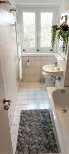 a bathroom with a tub and a toilet and a sink at Helles Apartment mit Balkon am Großen Garten nahe Stadtzentrum in Dresden