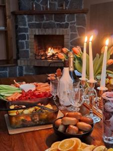 a table with food and candles and a fireplace at Viesu nams Vizbulītes in Talsi