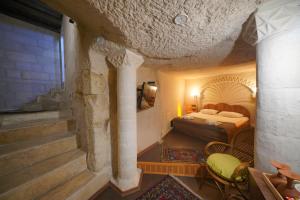 une chambre d'hôtel avec un lit et un escalier dans l'établissement View Cave Hotel, à Gorëme