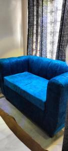 a blue couch sitting in front of a window at Khalisee Homes Studio Apartment 2 in Voi