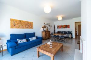 uma sala de estar com um sofá azul e uma mesa em Beach House Santa Eulália, Albufeira em Albufeira
