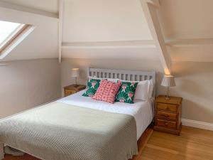 Menheniot的住宿－霍利韋爾穀倉度假屋，卧室配有白色的床和两盏灯。