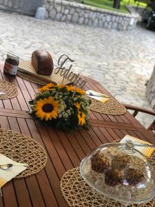 - une table en bois avec une assiette de nourriture et de fleurs dans l'établissement B&B La Quiete, à Massa Lubrense