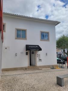 een wit gebouw met een zwarte luifel erop bij Alojamento Local Vitoria in Batalha