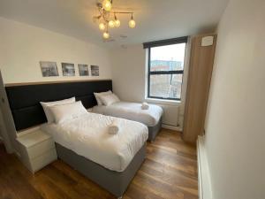 a bedroom with two beds and a window at Merve Apartments by Like Your Home LTD in Maidstone