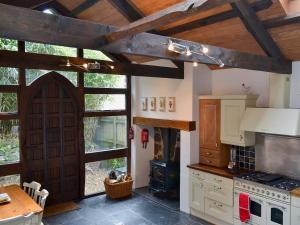 a kitchen with a wooden door and a stove at Hollywell Barn in Menheniot