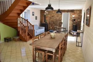 un salon avec une table et des chaises en bois dans l'établissement Blaz an Holen - Maison avec jardin à Guimaëc, à Saint-Jean-du-Doigt