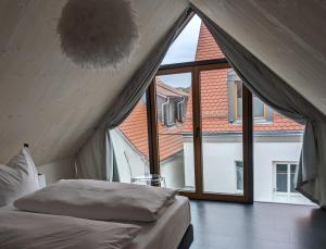 a bed in a room with a large window at Hotel-Weingut Bernard in Sulzfeld am Main