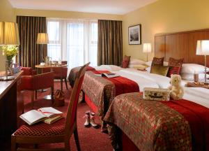 a hotel room with two beds and a teddy bear on a chair at The Rose Hotel in Tralee