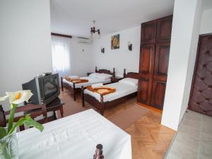 a living room with two beds and a tv at Guest House 4M in Petrovac na Moru
