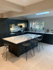 a kitchen with black cabinets and a table and chairs at 4 bedroomed luxury house in the heart of Beatles land in Childwall