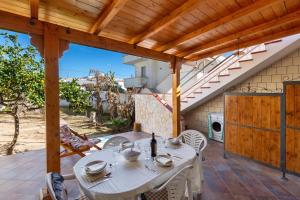 een patio met een tafel en stoelen en een trap bij Villetta delle Viole by BarbarHouse in Torre Ovo