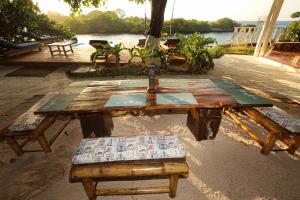 uma mesa de piquenique de madeira com dois bancos em Isla Mulata, Islas del Rosario em Isla Grande