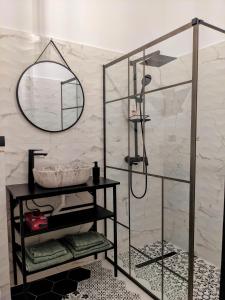 W łazience znajduje się prysznic i lustro. w obiekcie The Industrique Home - 3 Bedroom Apartment w mieście Timişoara