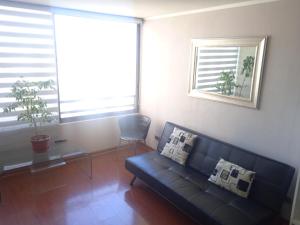 un soggiorno con divano, tavolo e finestre di Departamento Santiago Centro a Santiago