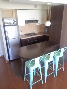 a kitchen with a table and chairs and a refrigerator at Departamento Santiago Centro in Santiago