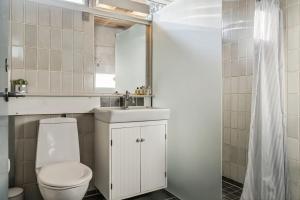 a bathroom with a toilet and a sink and a mirror at Charmerende sommerhus - 200 m fra stranden in Marielyst