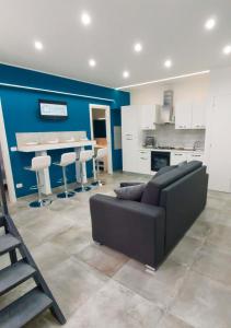 een woonkamer met een bank en een keuken bij Le Segrete del Castello, al centro Storico di Catania in Catania