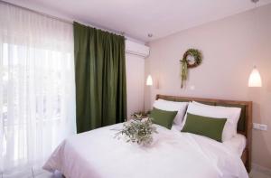 1 dormitorio con cama blanca y cortina verde en Lena Apartments 3, en Potos