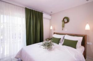 een slaapkamer met een wit bed en een groen gordijn bij Lena Apartments 3 in Potos