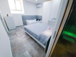 een kleine slaapkamer met een bed en een badkamer bij Le Segrete del Castello, al centro Storico di Catania in Catania