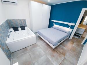 een slaapkamer met een bed en een bad en een bed bij Le Segrete del Castello, al centro Storico di Catania in Catania