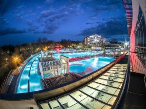 uma vista para uma grande piscina à noite em Hotel Astoria em Bad Füssing