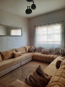ein Wohnzimmer mit einem Sofa und einem Fenster in der Unterkunft Bel Appartement à louer in Agadir