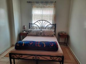 ein Schlafzimmer mit einem Bett mit einem schwarzen Rahmen und einem Fenster in der Unterkunft Bel Appartement à louer in Agadir