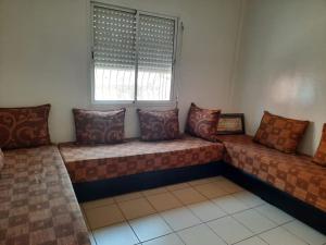ein Zimmer mit vielen Kissen auf einer Couch in der Unterkunft Bel Appartement à louer in Agadir