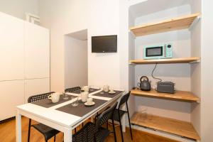 a room with a table and chairs and a microwave at La Mole Central & Comfy Apartment in Turin
