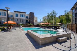 a pool at a hotel with tables and umbrellas at San Mateo 1br w pool gym wd nr Caltrain SFO-1237 in San Mateo