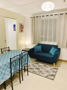 a living room with a blue couch and a bed at SM Southmall condo 2br unit with mall view in Manila