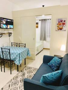 a living room with a blue couch and a table at SM Southmall condo 2br unit with mall view in Manila