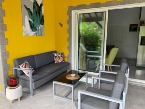 un soggiorno con divano e tavolo di Location villa et piscine privé a Capesterre-Belle-Eau