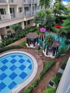 an overhead view of a swimming pool in front of a building at SM Southmall condo 2br unit with mall view in Manila