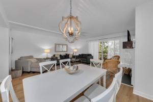 - une salle à manger et un salon avec une table et des chaises blanches dans l'établissement Seagrove Villa 5B - Oceanside Villa in the Trees, à Isle of Palms