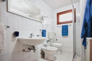 a white bathroom with a sink and a toilet at Case Bongiovi in Sciacca