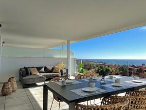 een woonkamer met een tafel en stoelen op een balkon bij Via Celere 2332 Luxury Sea View Apartment in Casares