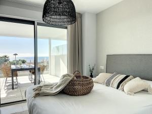 een slaapkamer met een bed met een mand erop bij Via Celere 2332 Luxury Sea View Apartment in Casares +29 foto's
