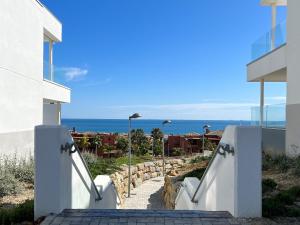 een trap die naar een huis met uitzicht op de oceaan leidt bij Via Celere 2332 Luxury Sea View Apartment in Casares