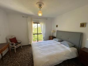 a bedroom with a white bed and a window at Casa El Chorro con magníficas vistas in El Chorro