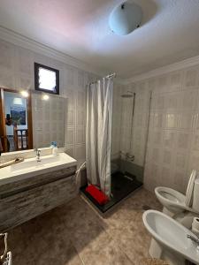 a bathroom with a sink and a shower and two toilets at Casa El Chorro con magníficas vistas in El Chorro
